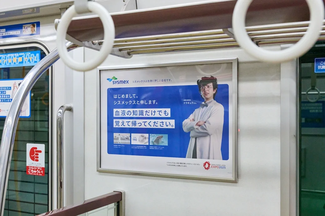 動画CMはオンライン、血液に関する知識は“留まって読める”電車内へ。動画CMのキャラクターを車内にも掲出し、同じ世界観でつないだ。接点ごとに役割を分けながら束ねることで、理解の深さを設計ししている